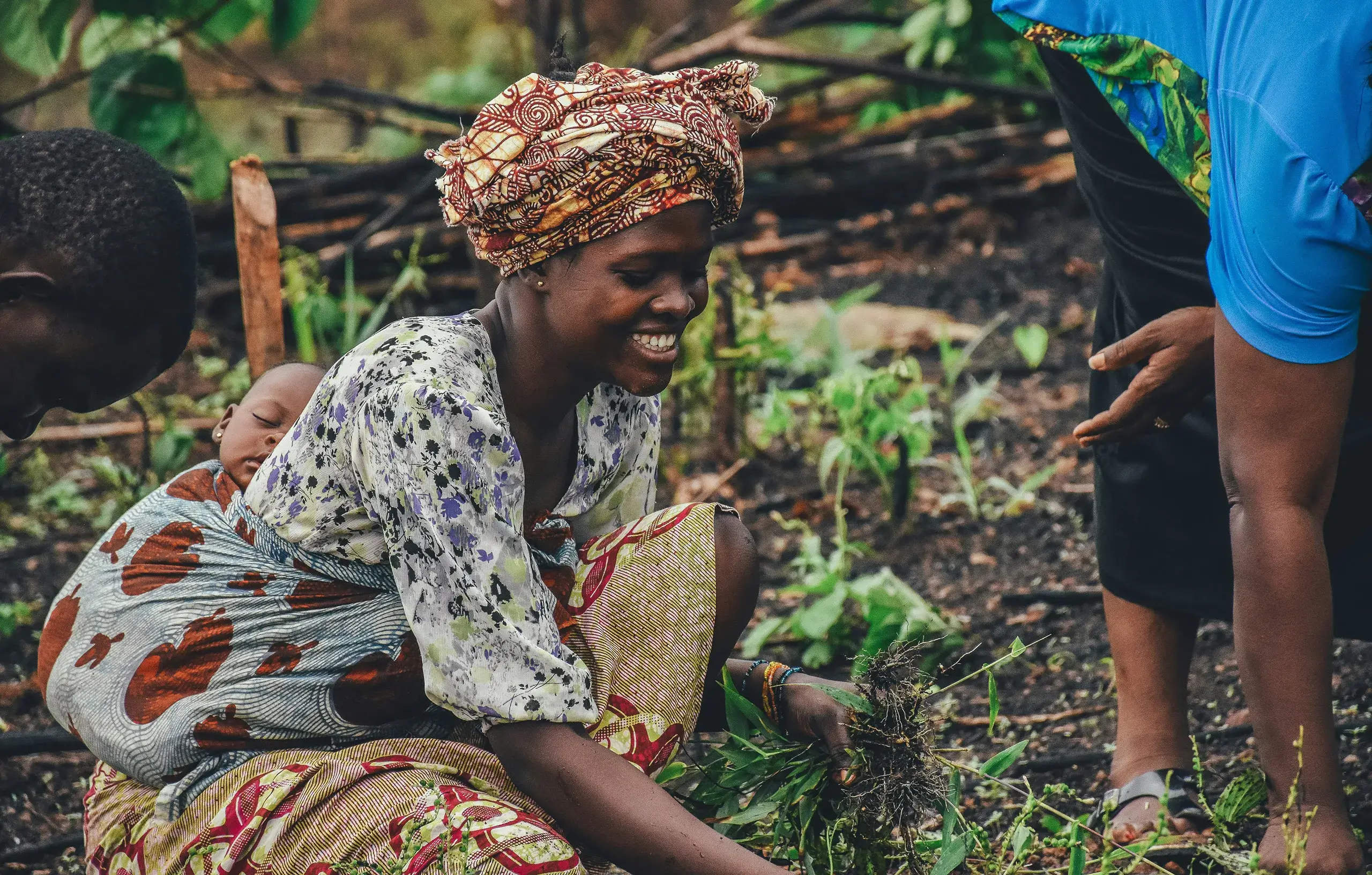 Woman carrying baby in field