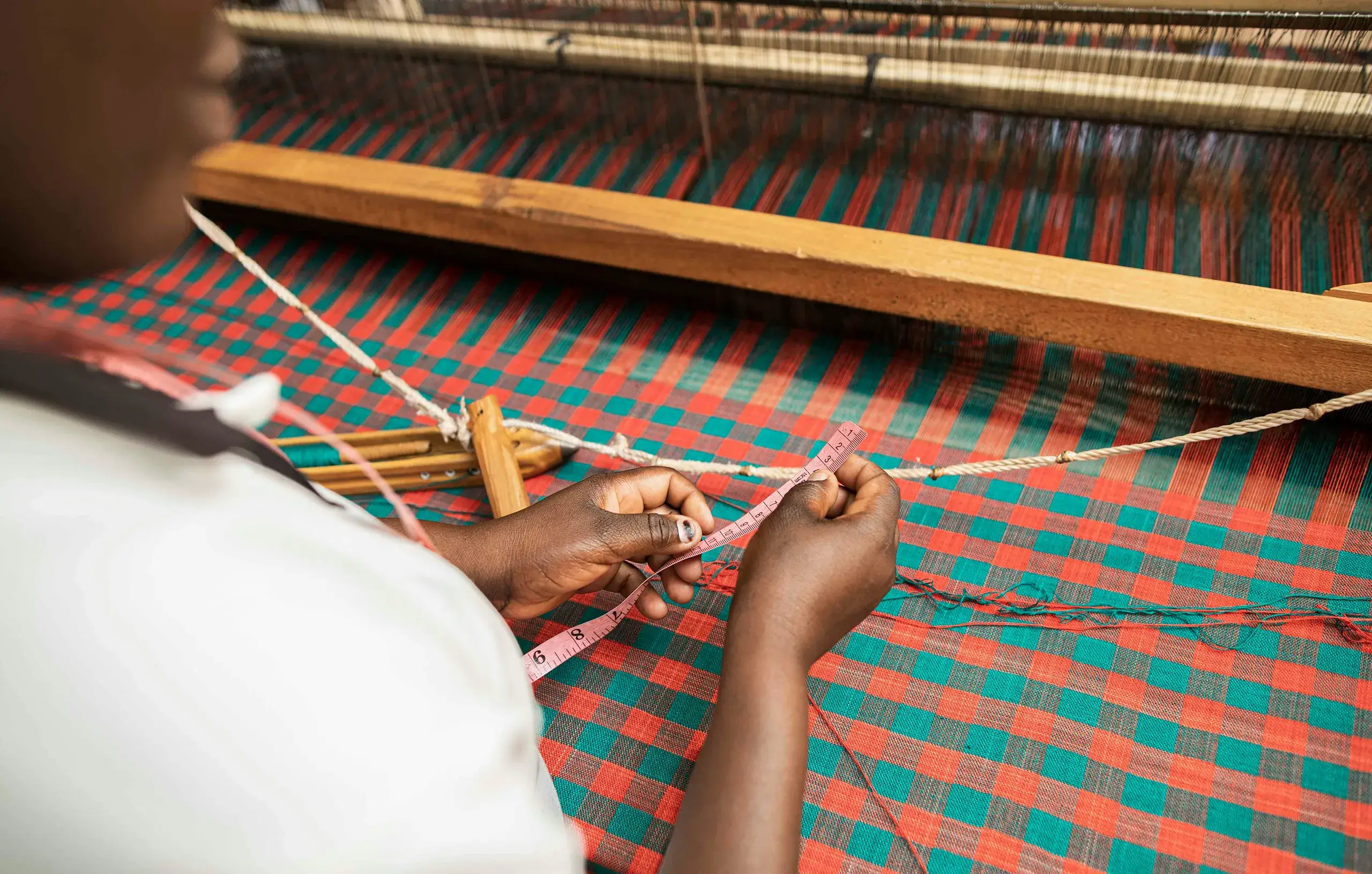 Person weaving colorful fabric