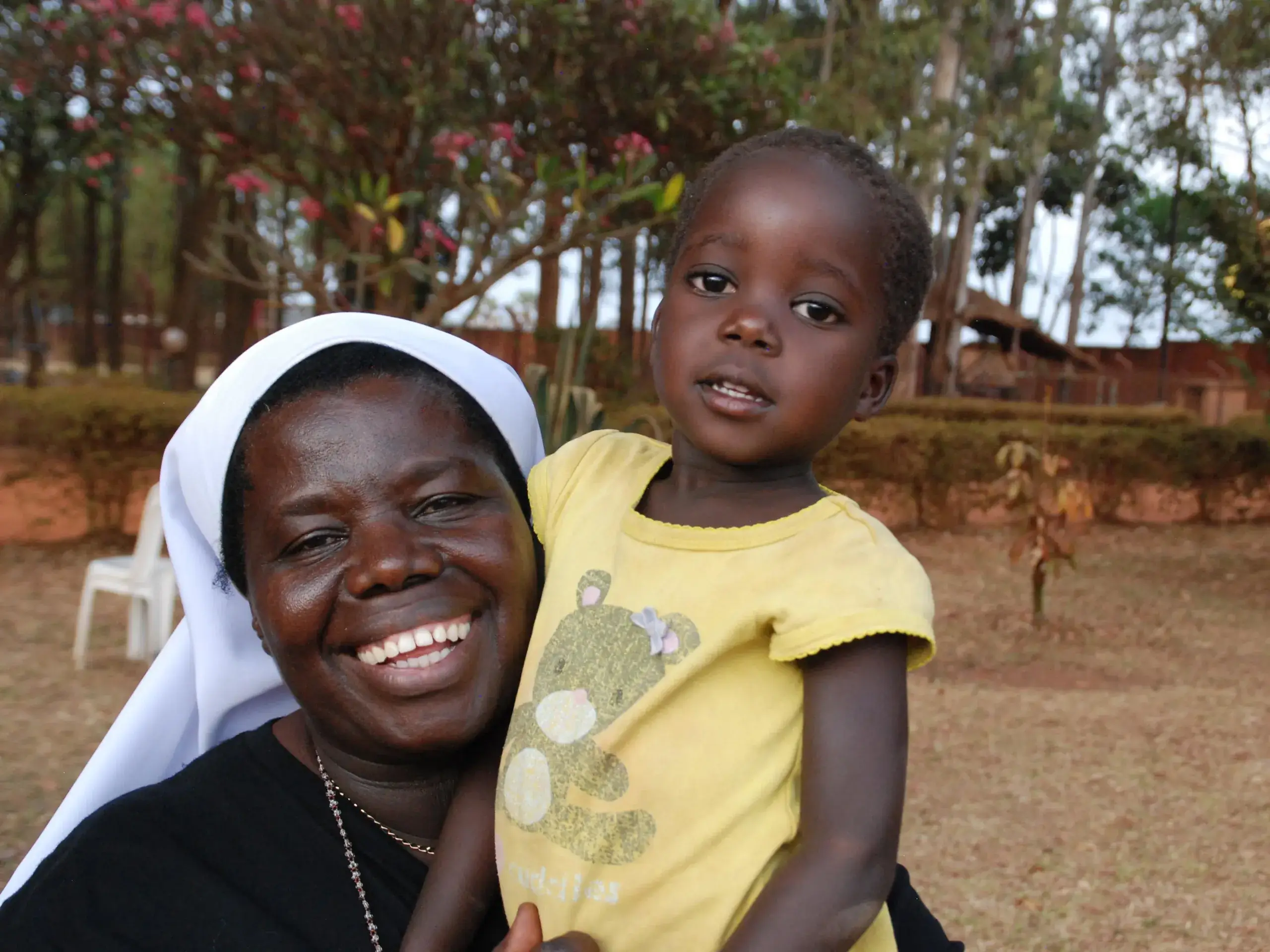 Sister Rosemary smiling while holding young child