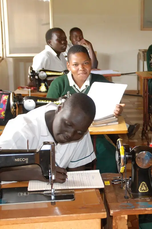 Young women in classroom learning how to sew